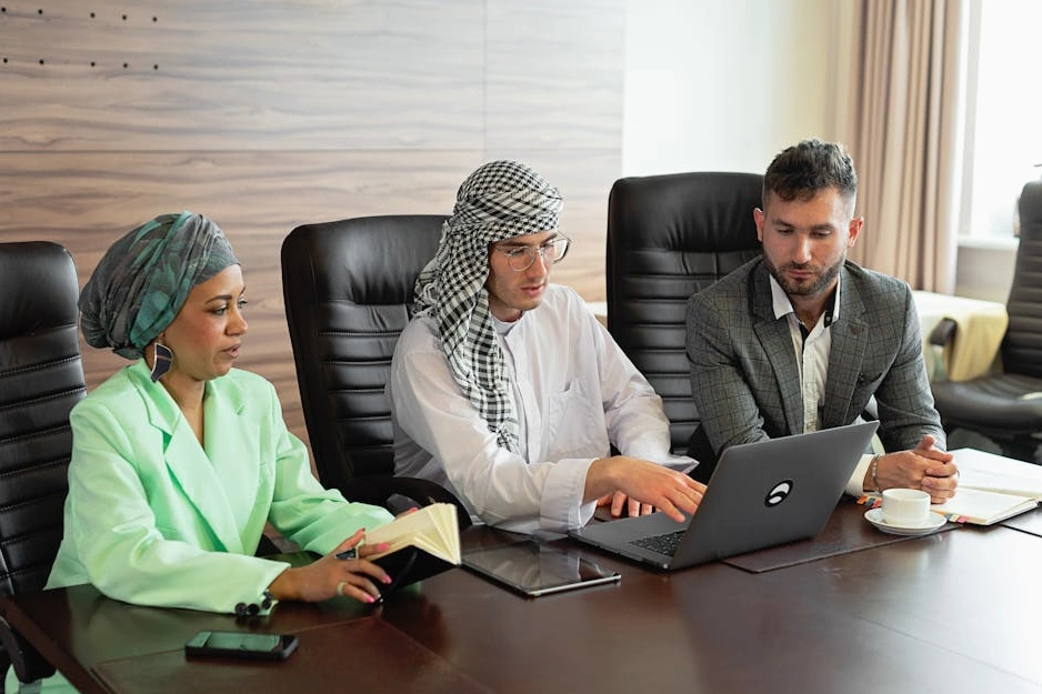 A team of professionals in a modern office reviewing compliance documents.
